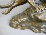 a bronze statue of a lion on a rock