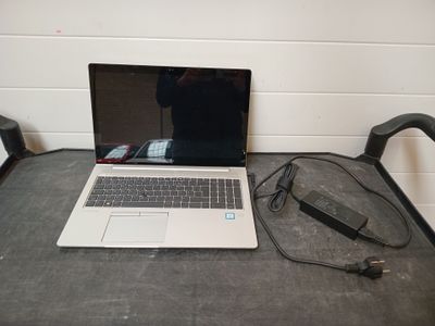 un ordinateur portable posé sur une table avec un chargeur