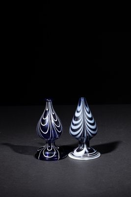 two blue and white vases sitting on top of a black table