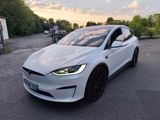 une Tesla Model X blanche garée sur un parking