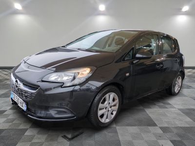 a black opel parked in a room with a checkered floor