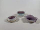 three pieces of pottery sitting on top of a table next to each other