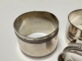 two silver napkin rings on a white surface