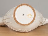 a white porcelain bowl with a gold rim on a wooden table