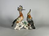 deux figurines représentant des oiseaux perchés sur une branche d'arbre