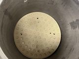 a close up view of a metal bowl with holes in it