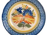 a blue and yellow plate with a flower design on it