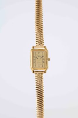 a close up of a gold wrist watch with a chain around it