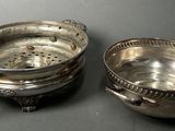 pair of silverplated bowls with handles and handles on a table