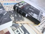 books on a bed with newspapers and newspapers in the background