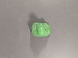 a small green frog sitting on top of a table
