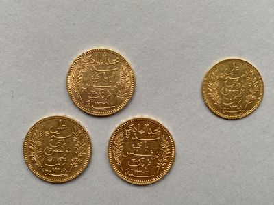 quatre pièces d'or sont représentées sur une surface blanche