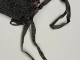 un petit sac noir orné d'un ruban noir