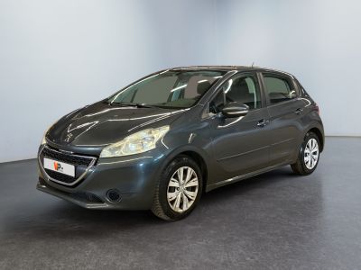 La voiture grise est garée dans une grande pièce au sol noir.