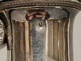 a silver vase that is sitting on a table