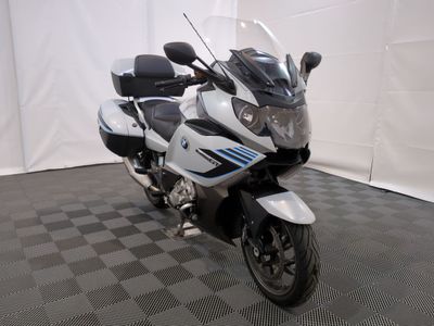 une photo d'une moto blanche et noire garée sur un sol à damier
