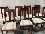 six chaises et une table sur laquelle est posé un coussin rayé