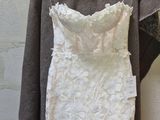 a wedding dress hanging on a hanger next to a coat