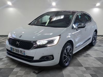 une voiture blanche est garée dans une grande pièce au sol en damier