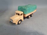 a toy truck with a green cover on the back