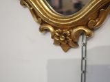 a mirror hanging on the wall with a chain around it