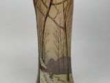 a vase that has a picture of trees on it