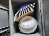 a stack of plates and bowls in a metal container