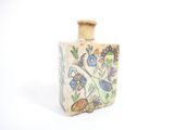 a small vase with a painting on it sitting on a table