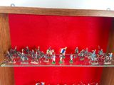 many figurines displayed on glass shelves in a display case