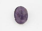 une image représentant une bague en pierre violette sur laquelle est gravé un visage