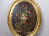 tableau représentant un vase de fleurs dans un cadre doré, accroché à un mur blanc