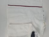 the pocket of a pair of white pants with a red stripe