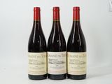 trois bouteilles de vin posées sur une table l'une à côté de l'autre