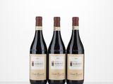 three bottles of red wine sitting on top of a table