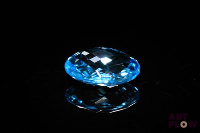 a close up of a blue diamond on a black surface