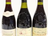three bottles of wine are lined up on a white surface