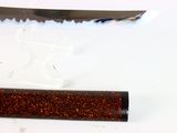 a knife that is sitting next to a tube of glitter