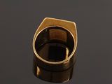 a close up of a gold ring on a black surface