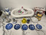 a table with a sink, plates, cups, and a teapot on it