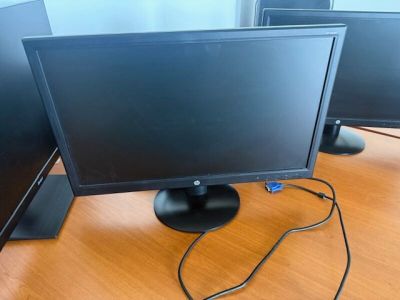 trois écrans d'ordinateur posés sur un bureau en bois