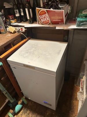 un petit réfrigérateur blanc dans le coin d'une cuisine