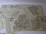 plusieurs vieilles cartes de l'Europe sur une feuille de papier posée sur une table