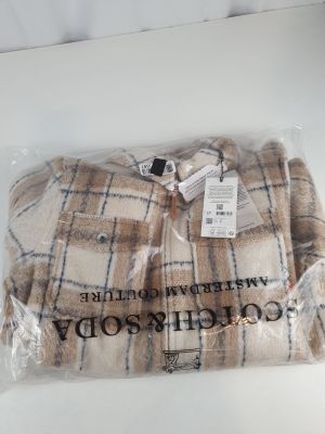 Le pull est emballé dans un sac en plastique posé sur la table.
