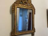 two mirrors hanging on the wall next to each other