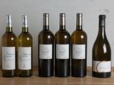 plusieurs bouteilles de vin sont alignées sur une table en bois