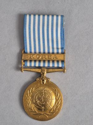 une image représentant une médaille d'or ornée d'un ruban bleu et blanc