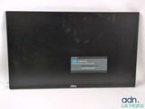 the dell laptop is sitting on a white surface with a blue button