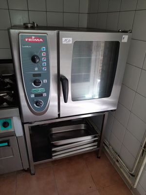 un four argenté posé dans une cuisine, à côté d'une cuisinière