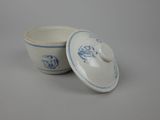 two small blue and white bowls with lids sitting on a table