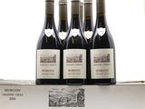 trois bouteilles de vin rouge posées sur une boîte blanche